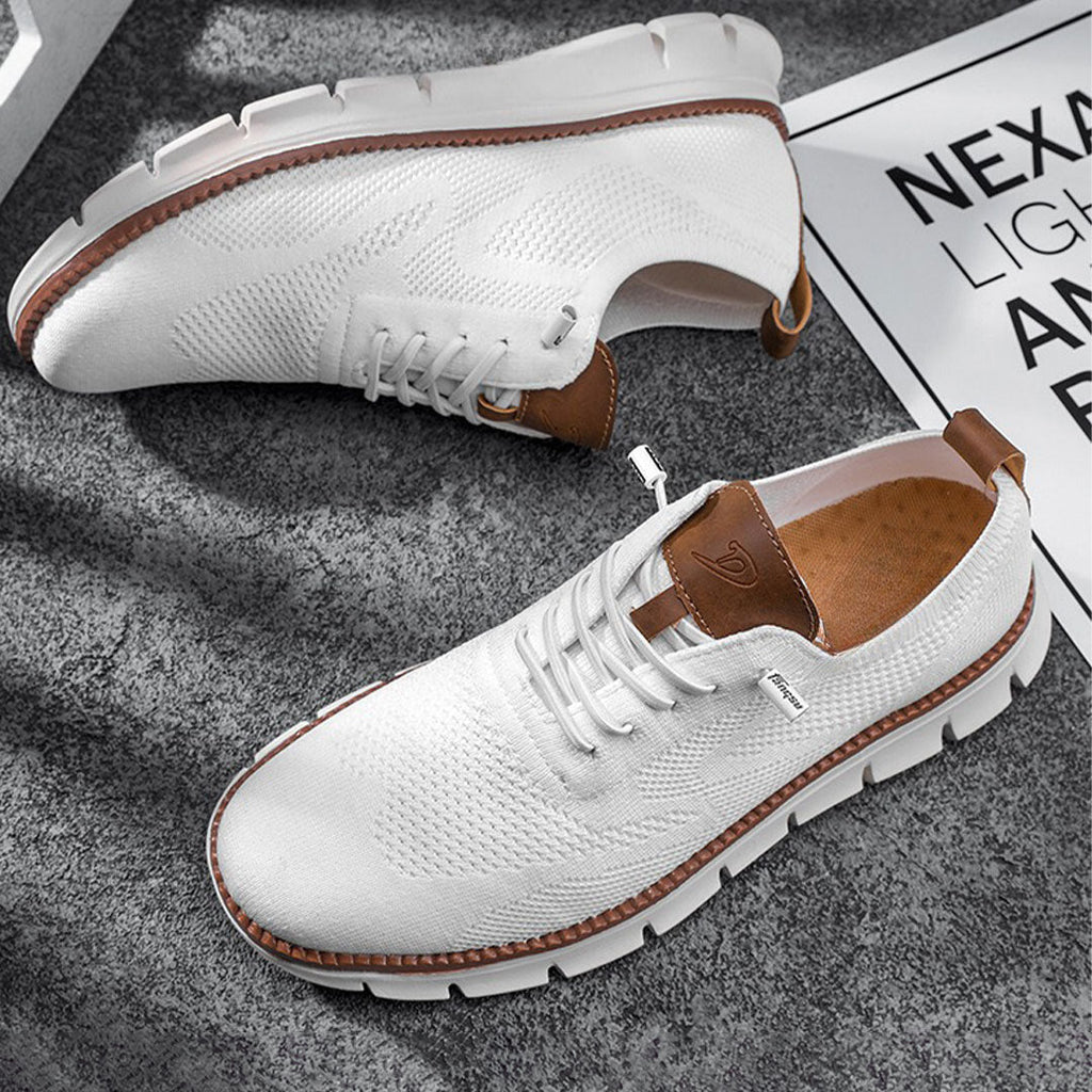 Chaussures de sport blanches pour hommes avec semelle épaisse, détails marron, sur fond gris. Style moderne et confortable, idéal pour la mode urbaine.