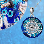 Pendentif œil bleu en verre avec motif soleil argenté, symbole de protection contre le mauvais œil, sur fond bleu. Accessoire porte-bonheur tendance.
