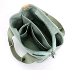 Sac à main vert menthe en toile avec plusieurs compartiments, fermeture éclair et poignées robustes. Accessoire mode pratique et tendance.