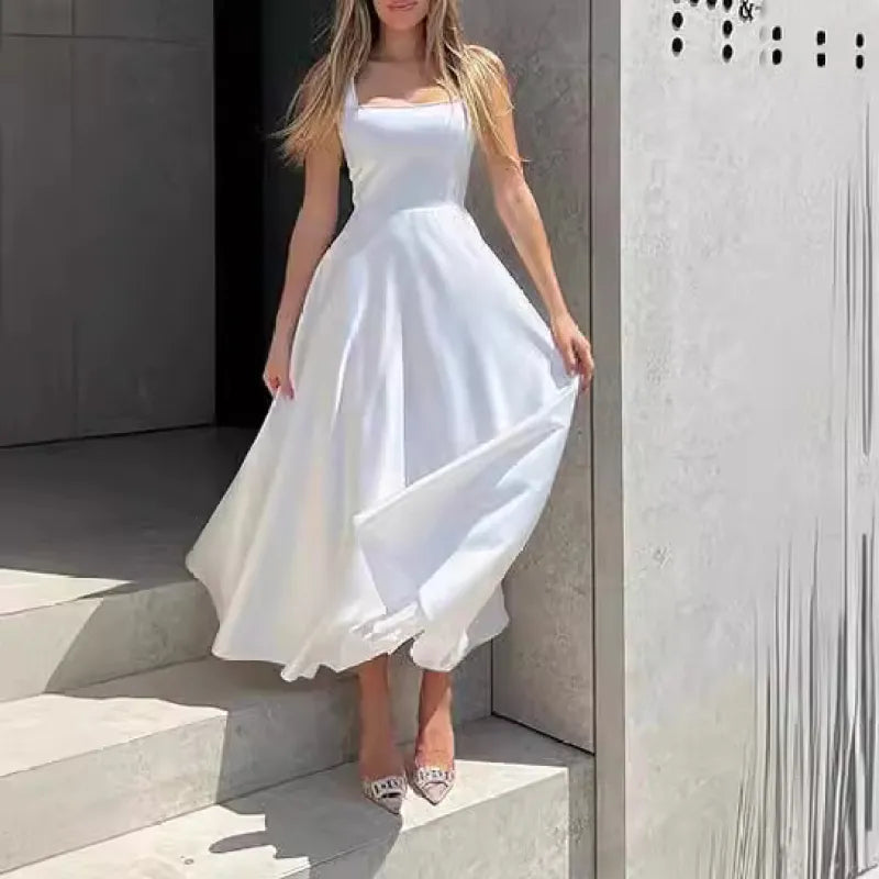 Femme en robe blanche élégante sur des marches en pierre, robe longue fluide, style chic et moderne, mode féminine, tenue estivale.
