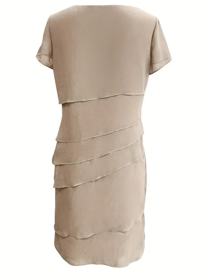 Robe beige élégante à volants superposés, manches courtes, style chic et moderne, idéale pour soirées ou événements formels.