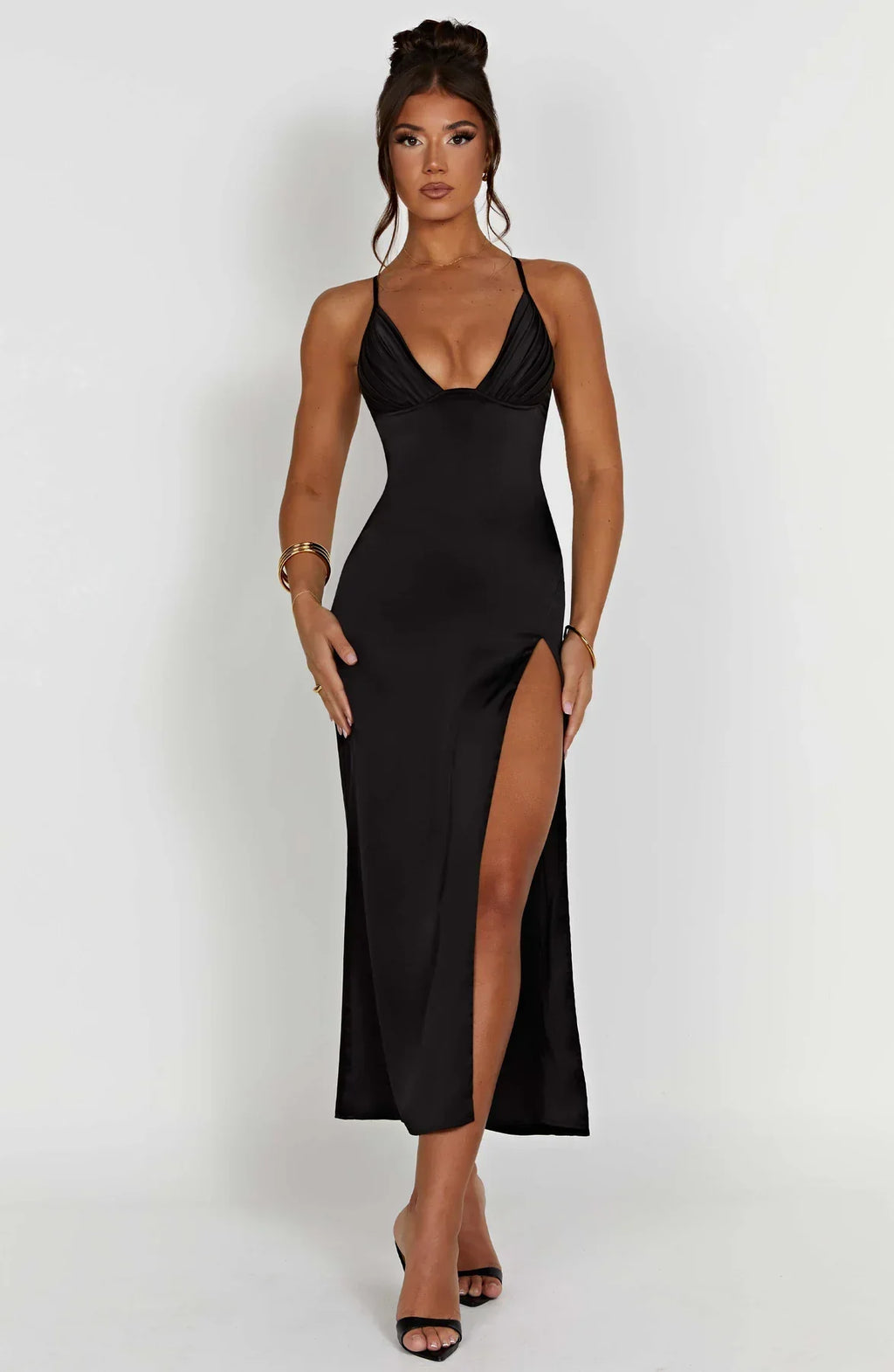 Robe longue noire élégante avec fente haute, bretelles fines, portée par une femme. Mode soirée chic, tendance, glamour.