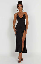 Robe longue noire élégante avec fente haute, bretelles fines, portée par une femme. Mode soirée chic, tendance, glamour.