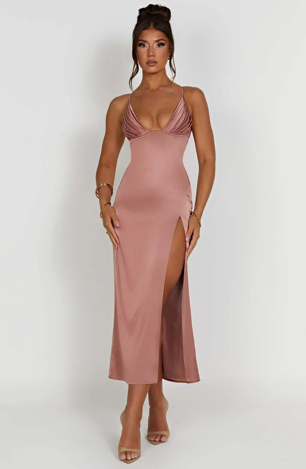 Robe longue rose satinée avec fente haute, décolleté plongeant, portée par une femme. Mode élégante, tenue de soirée chic, tendance 2023.