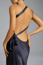 Robe dos nu en satin noir, élégante et moderne, avec bretelles croisées et nœud latéral. Mode féminine chic et tendance.