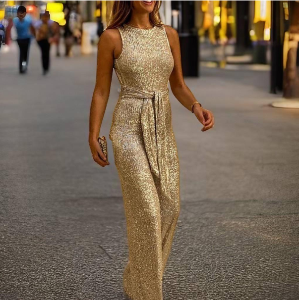 Robe longue dorée à paillettes portée par une femme marchant en ville, tenue élégante de soirée, mode glamour, style chic urbain.