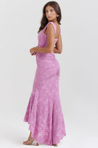 Femme en robe longue rose en dentelle, élégante et ajustée, posant de profil. Mode féminine, tenue de soirée chic, style glamour.
