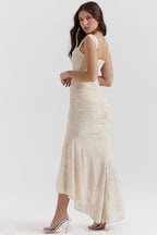 Robe longue en dentelle beige, élégante et ajustée, portée par une femme de profil. Mode féminine, tenue de soirée chic, style glamour.
