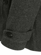 Manteau en laine gris foncé avec boutons noirs, texture épaisse et manche repliée. Mode hiver élégante, vêtement chaud pour homme.