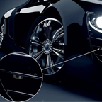 Voiture de luxe noire avec jantes chromées brillantes et phares LED allumés, gros plan sur la poignée de porte élégante.