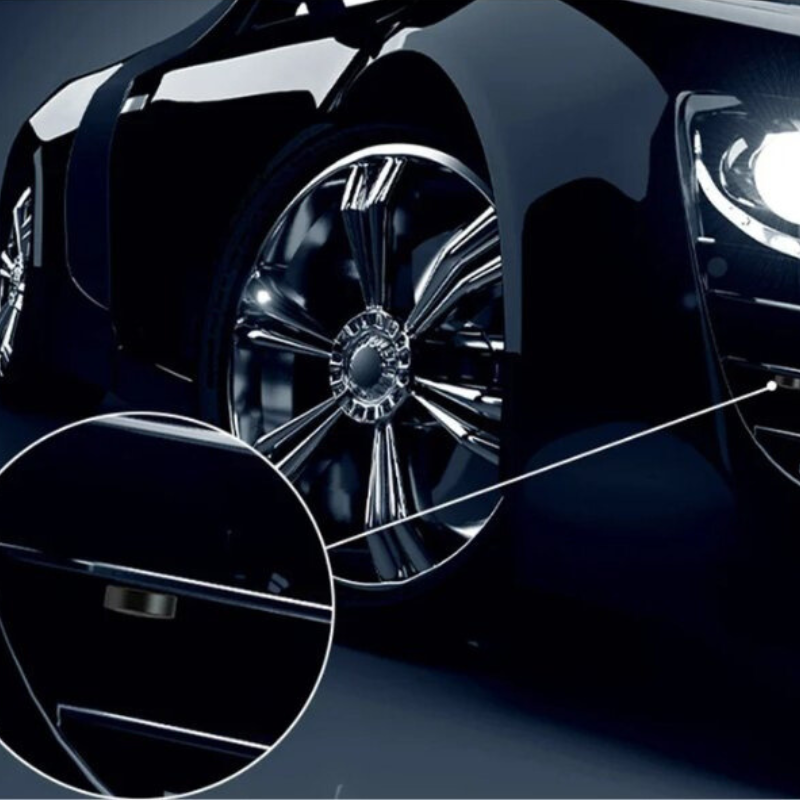 Voiture de luxe noire avec jantes chromées brillantes et phares LED allumés, gros plan sur la poignée de porte élégante.