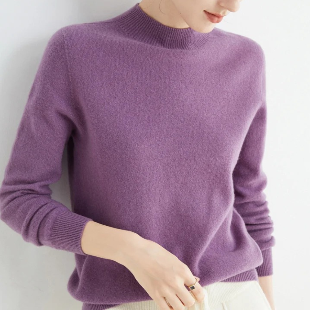 Femme portant un pull en cachemire violet, manches longues, col rond, style élégant et moderne, mode automne-hiver, confort et chaleur.