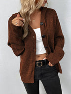 Femme portant un cardigan marron en tricot avec boutons, débardeur blanc, jean noir. Mode automne, style décontracté, tendance féminine.