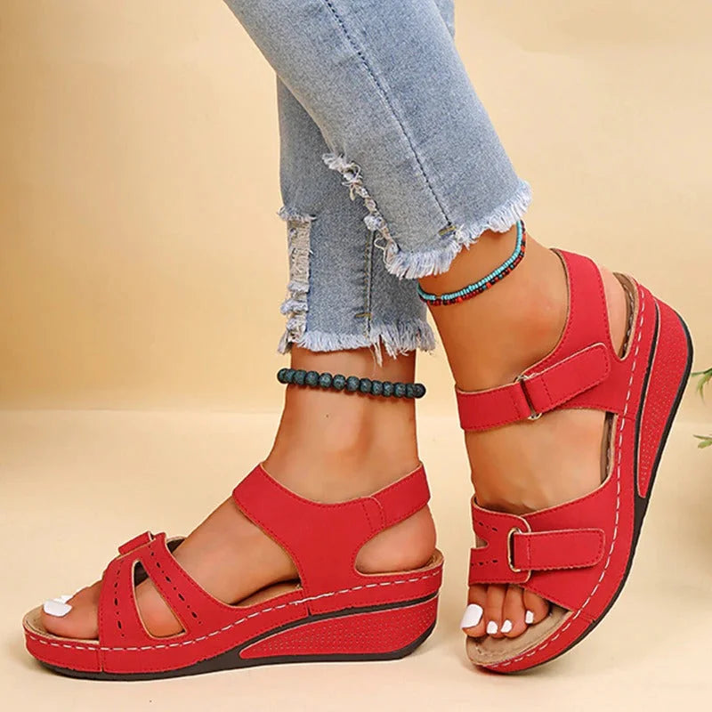 Sandales rouges à plateforme avec lanières ajustables, portées avec un jean déchiré. Chaussures d'été confortables pour femmes.