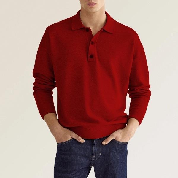 Homme portant un pull rouge à col polo, manches longues, avec un jean bleu. Mode masculine élégante et décontractée.