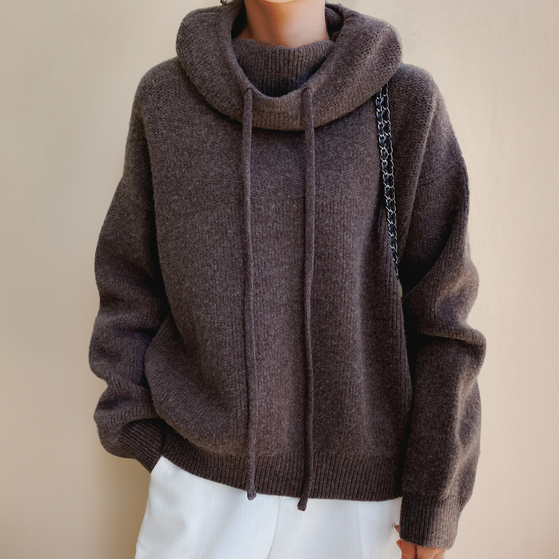 Pull-over en laine marron avec capuche et cordons, porté par une personne. Mode automne-hiver, style décontracté, confort et élégance.