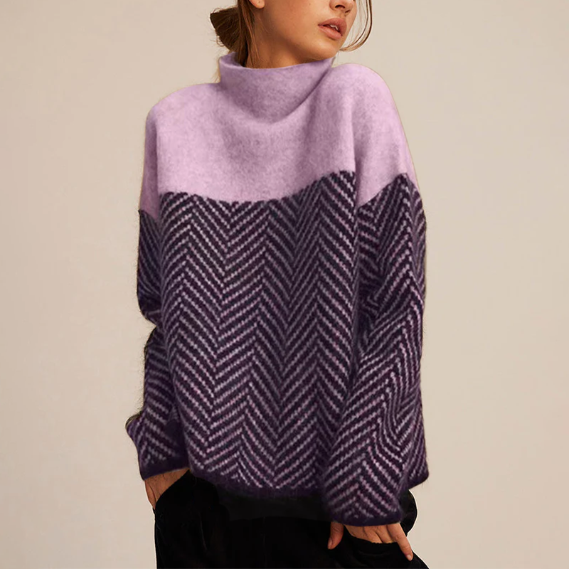 Femme portant un pull en laine violet et rose à motif chevron, col montant. Mode automne-hiver, style décontracté et élégant.