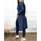 Femme portant un ensemble bleu marine élégant, tunique longue et leggings, posant dans un intérieur moderne. Mode féminine, tenue décontractée chic.