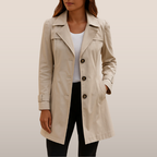 Femme portant un trench-coat beige élégant, manches longues, boutons marron, sur fond neutre. Mode automne, manteau classique, style intemporel.