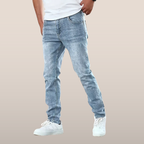 Jean slim homme bleu clair délavé, porté avec un t-shirt blanc et des baskets blanches. Mode masculine décontractée, style moderne et tendance.