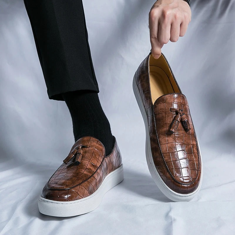 Chaussures mocassins en cuir marron à motif croco, semelle blanche, portées avec un pantalon noir. Style élégant et moderne pour homme.