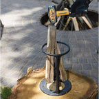 Fendeur de bûches manuel en métal sur une souche, utilisé avec un marteau pour fendre du bois. Outil de jardinage robuste et pratique pour couper du bois.