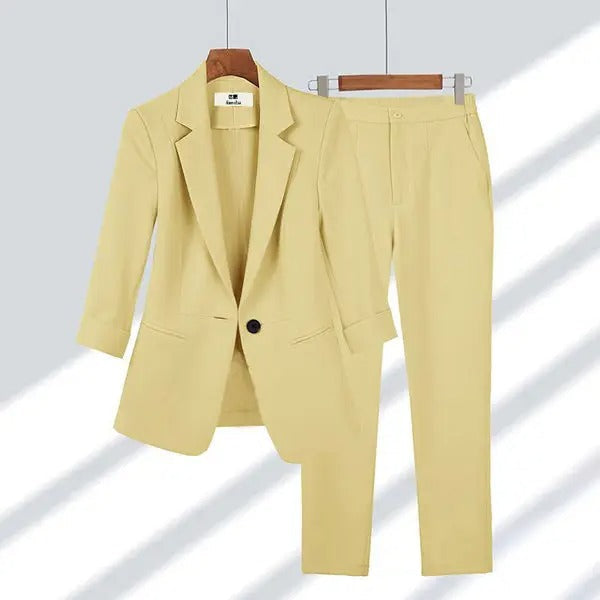Costume femme élégant beige clair, veste à un bouton et pantalon ajusté, suspendu sur cintres, mode professionnelle, tenue de bureau chic.