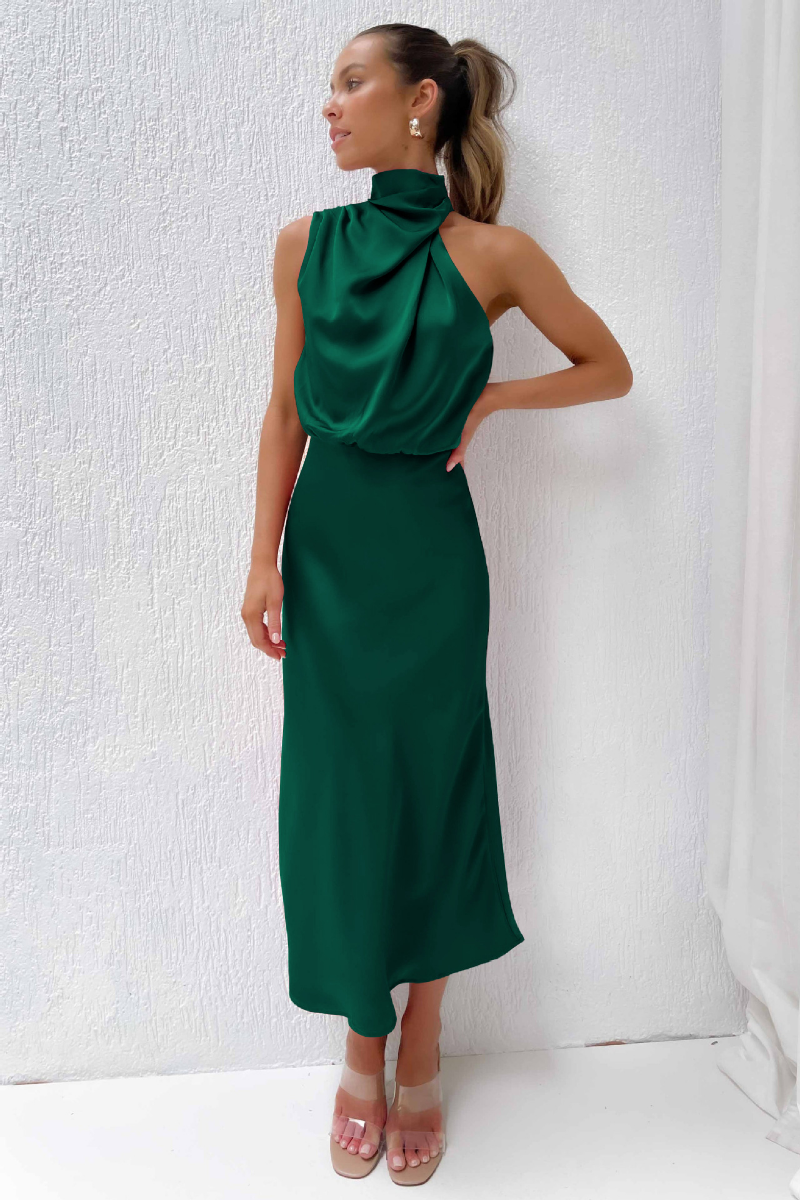 Robe longue verte élégante, sans manches, col haut drapé, portée par une femme. Mode féminine chic, tenue de soirée tendance.
