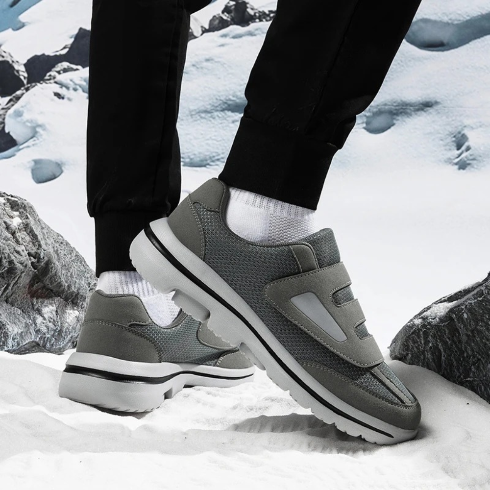 Chaussures de sport grises pour homme sur neige, design moderne et confortable, semelle antidérapante, idéale pour activités hivernales.