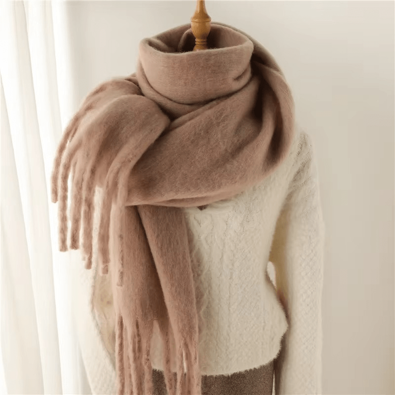 Écharpe en laine beige sur mannequin, drapée sur un pull blanc en tricot. Accessoire d'hiver élégant, mode féminine, confort et chaleur.