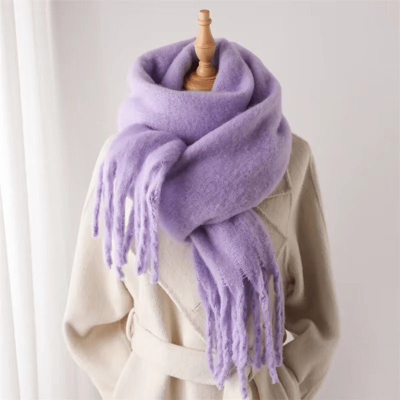 Écharpe en laine mauve douce et épaisse avec franges, enroulée sur un mannequin beige, idéale pour l'hiver et la mode féminine élégante.