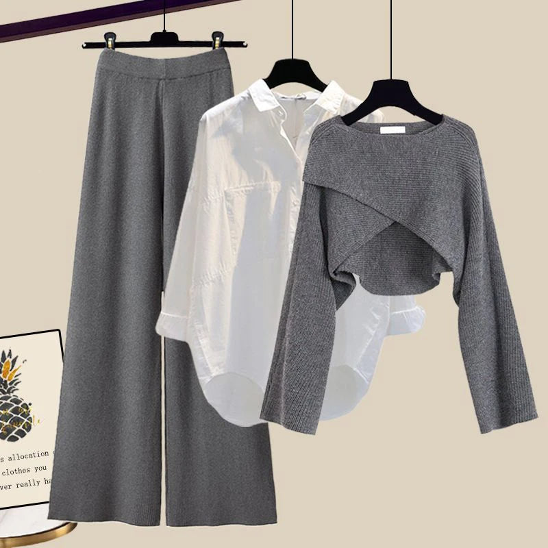Tenue élégante femme : chemise blanche, pull gris court, pantalon large gris. Mode automne-hiver, style chic et décontracté.