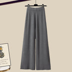 Pantalon large gris suspendu sur cintre, style élégant et moderne, idéal pour tenues professionnelles ou décontractées. Mode femme automne-hiver.