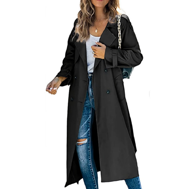 Femme portant un trench-coat noir élégant, jeans déchirés et t-shirt blanc, accessoirisé d'un sac à main. Mode automne chic et tendance.