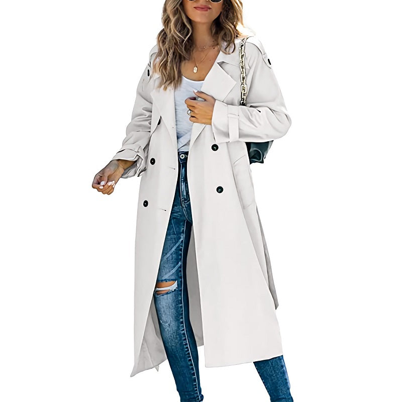 Femme portant un trench-coat blanc élégant, jeans déchirés et sac à main noir. Mode automne, style urbain chic, tendance vestimentaire.