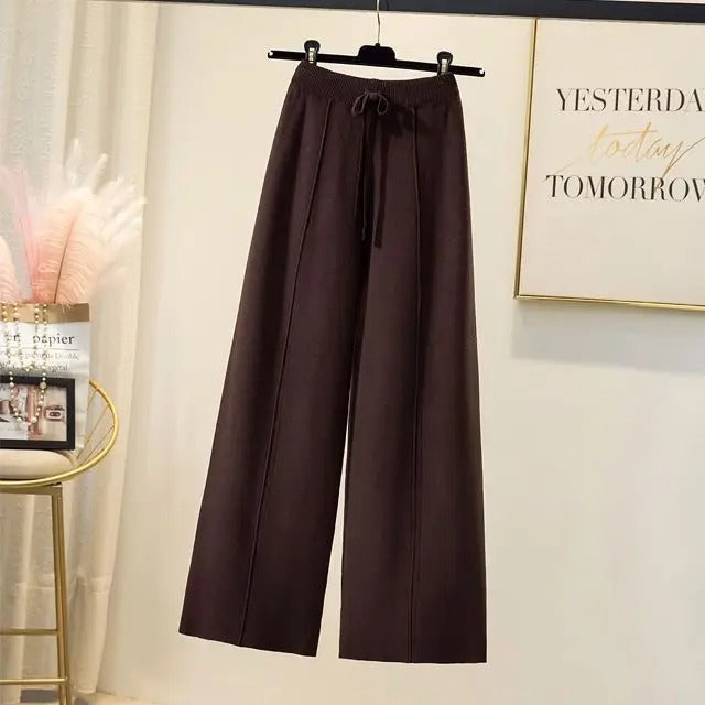 Pantalon large marron suspendu sur cintre, intérieur moderne, décoration murale inspirante, style décontracté, mode féminine élégante.