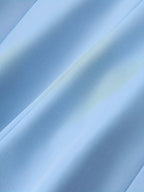 Tissu bleu clair en gros plan, texture douce et fluide, idéal pour la couture et la mode. Fond textile élégant et moderne.