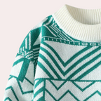 Pull en tricot vert et blanc avec motif géométrique, col rond côtelé. Mode hiver, style moderne, tendance vêtements chauds.