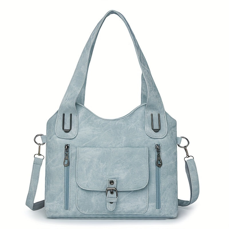 Sac à main en cuir bleu clair avec bandoulière amovible, poches zippées et boucle décorative. Accessoire mode élégant et pratique pour femme.