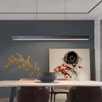 Suspension moderne noire au-dessus d'une table à manger, décor minimaliste avec tableau artistique et mur gris, éclairage intérieur design.