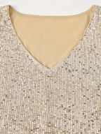 Robe à paillettes dorées avec col en V, tissu scintillant, mode élégante, tenue de soirée glamour, détail de couture raffinée.