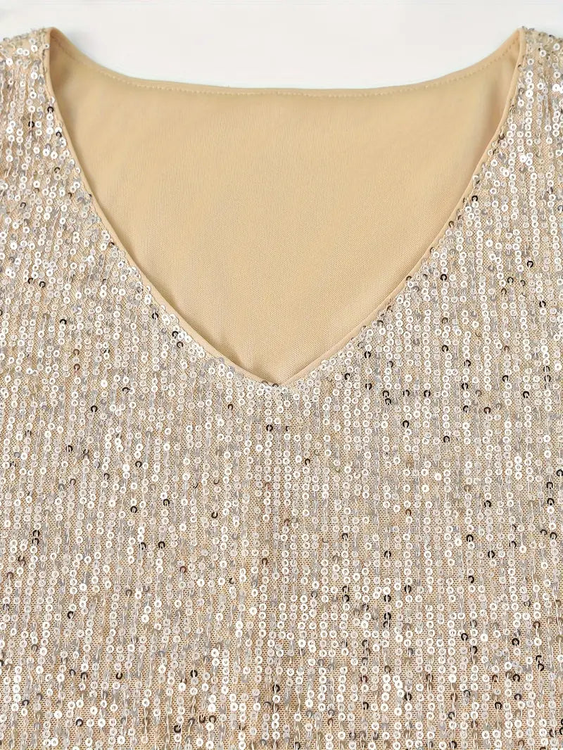 Robe à paillettes dorées avec col en V, tissu scintillant, mode élégante, tenue de soirée glamour, détail de couture raffinée.
