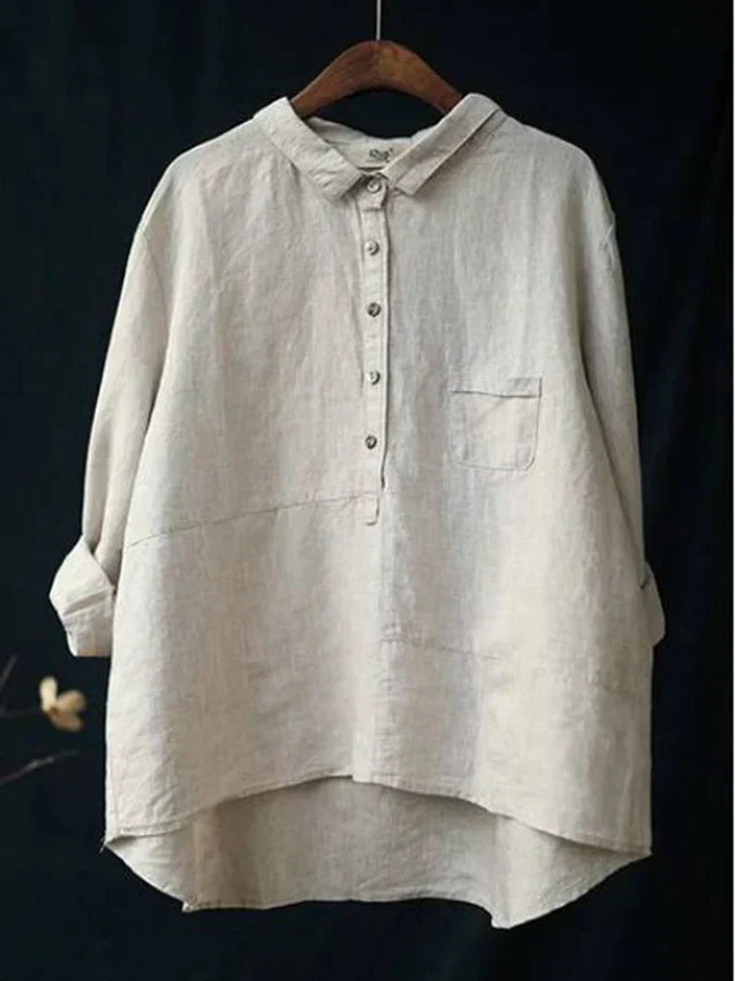 Chemise en lin beige pour femme, manches longues retroussées, col boutonné, poche poitrine, style décontracté, suspendue sur un cintre en bois.
