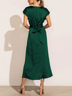 Robe longue verte élégante en satin, vue de dos, avec ceinture nouée, portée par une femme. Mode féminine chic, tendance robe soirée.