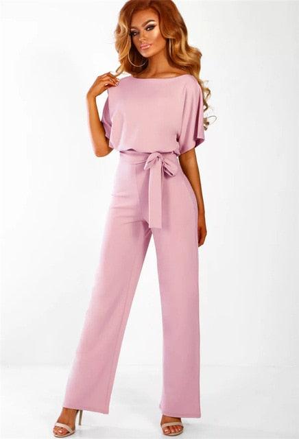 Combinaison rose élégante pour femme avec ceinture nouée, manches courtes et coupe ample. Mode féminine chic, tenue tendance pour soirée ou événement.