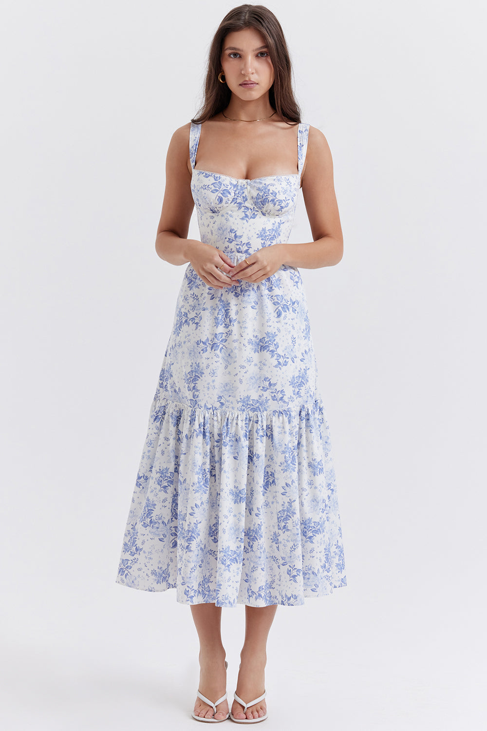 Robe d'été longue à fleurs bleues et blanches, bretelles larges, portée par une femme. Mode féminine élégante, style décontracté chic.