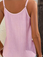 Débardeur rose en tissu texturé, dos nu, bretelles fines, porté par une femme. Mode estivale, style décontracté, tendance féminine.