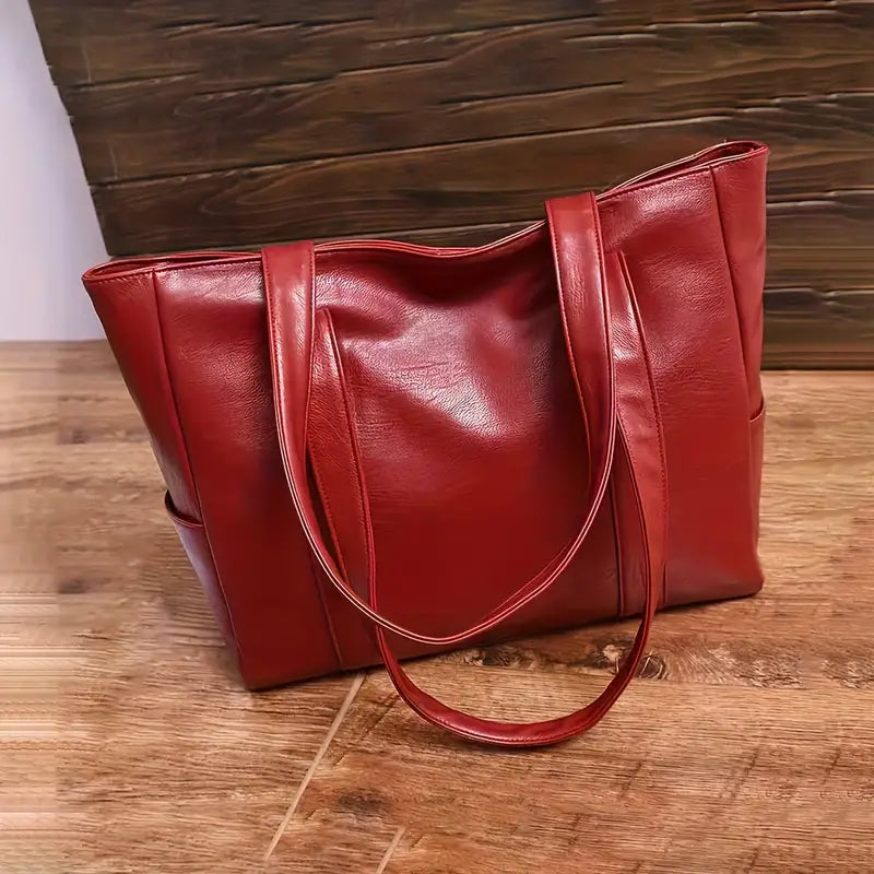 Sac à main en cuir rouge sur une table en bois, design élégant et moderne, accessoire de mode pour femme, parfait pour le quotidien et les sorties.
