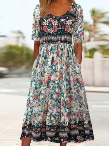 Robe longue bohème à motifs floraux multicolores, manches mi-longues, col rond, fond blanc, idéale pour l'été et les occasions décontractées.