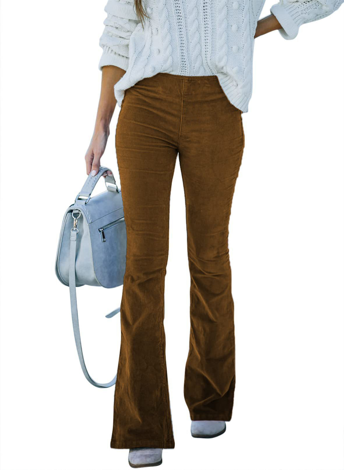 Femme en pull blanc et pantalon en velours marron, tenant un sac à main bleu. Mode automne, style décontracté chic, tendance féminine.